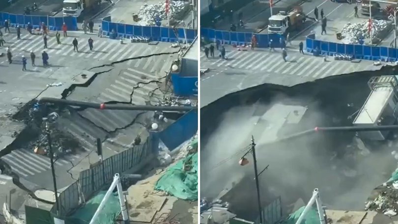 A massive sinkhole has opened up on a busy street in Shanghai, China, leaving construction workers running for their lives.