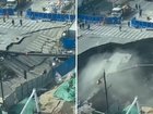 A massive sinkhole has opened up on a busy street in Shanghai, China, leaving construction workers running for their lives.