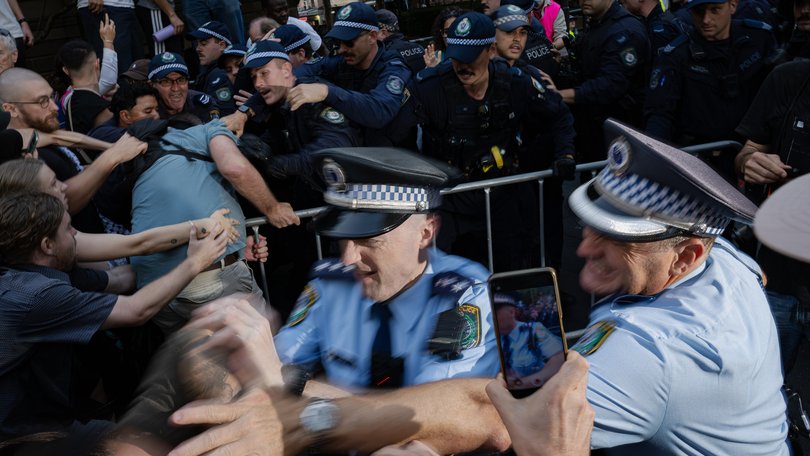 Police officers detain demonstrators during a protest in Sydney.