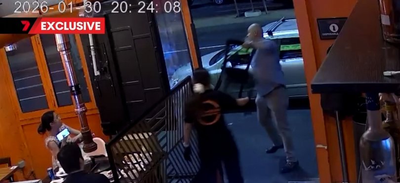 Furniture executive Tony Rogers holding a chair before throwing it at security outside a strip club on King St, Melbourne.