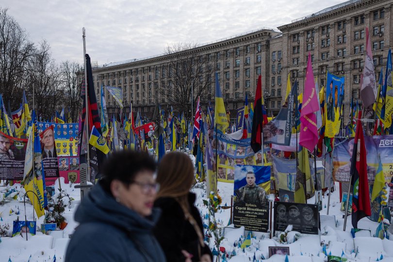 People walk amongst a makeshift memorial to fallen soldiers in Kyiv on February 17.