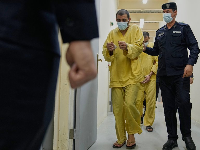 Iraqi security with suspected IS militants in a Baghdad prison.