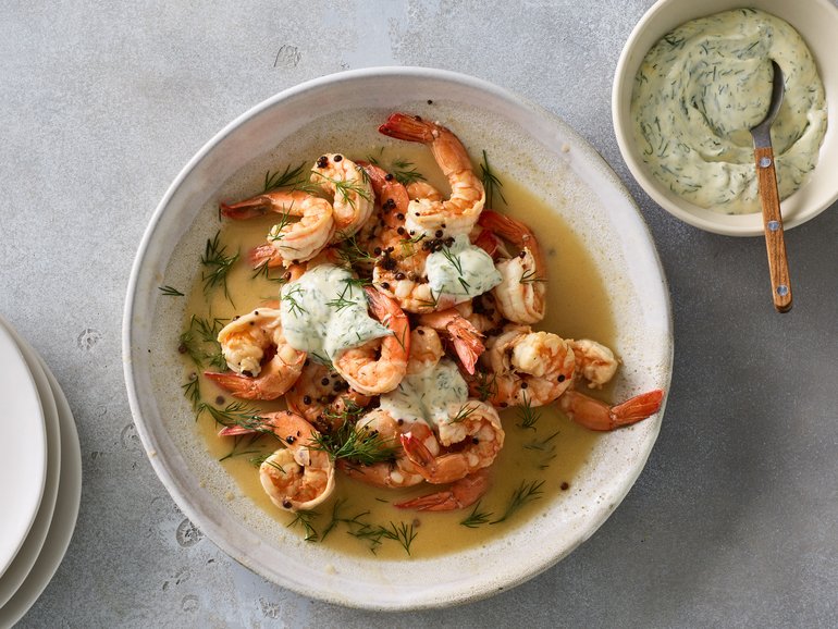 Butter-poached prawns with dill mayonnaise in New York, March 8, 2023. Nix the garlic for coriander seeds and a dollop of dill-speckled mayo for a subtle, speedy dish that’s all about the prawns. Food styled by Barrett Washburne. (James Ransom/The New York Times)