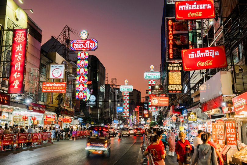 Chinatown at dusk, Bangkok Thailand. Illuminated signs on a busy street.