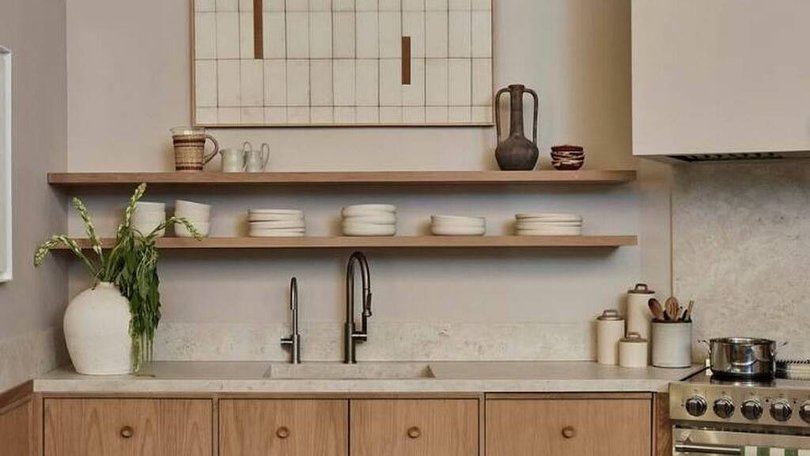 An oak panelled kitchen features warm neutrals and stone bench tops. Pic: Instagram/archdigest.