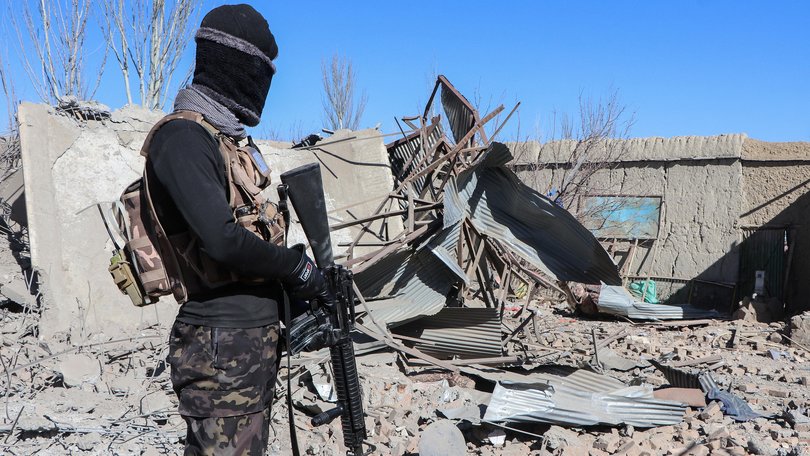 A Taliban security personnel stands next to the debris of houses destroyed during an overnight Pakistani airstrike at the Balish village in Urgun district, Paktika Province earlier in the week.