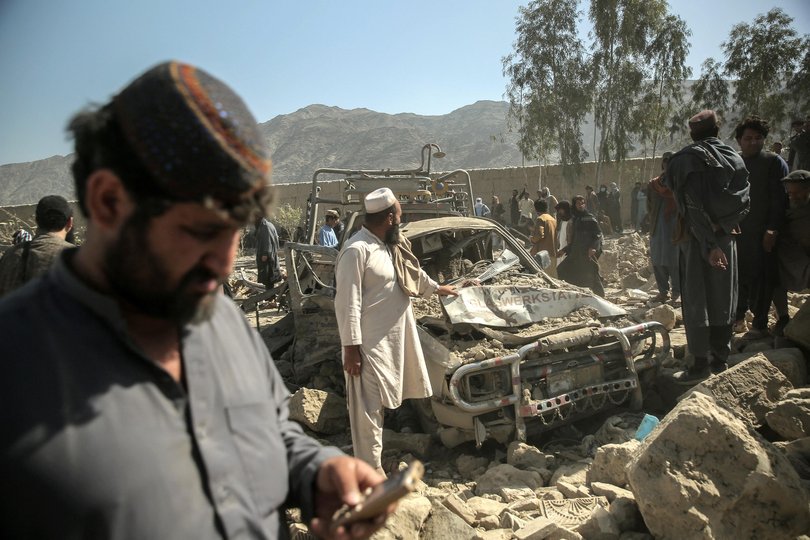 Afghan men gather near a damaged car after an overnight Pakistani airstrike hit a residential area at the Girdi Kas village in Bihsud district, Nangarhar province earlier in the week.