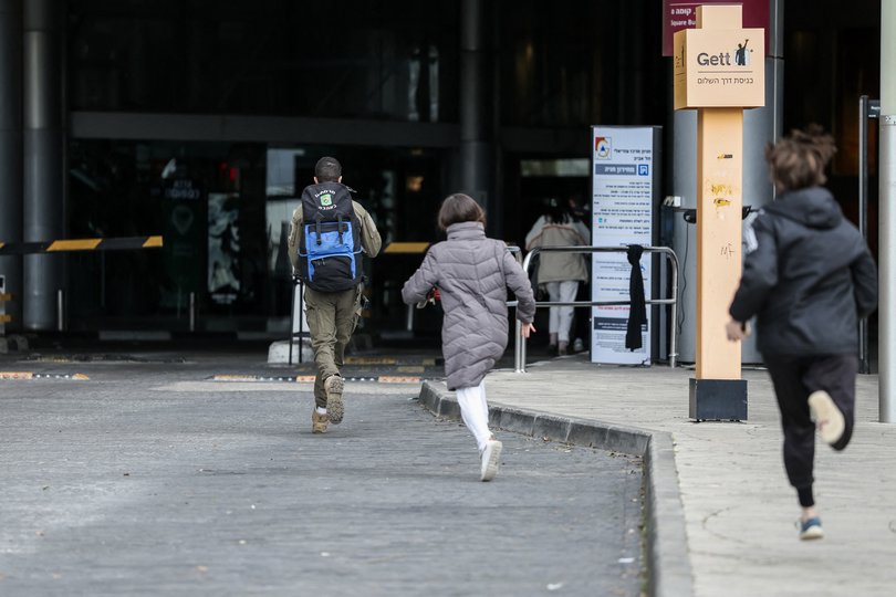 People run to take shelter after sirens sounded in Tel Aviv.
