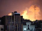 Smoke and flames rise behind buildings after an explosion on the second consecutive day of strikes by the US and Israel, in Tehran, Iran, 01 March 2026. 