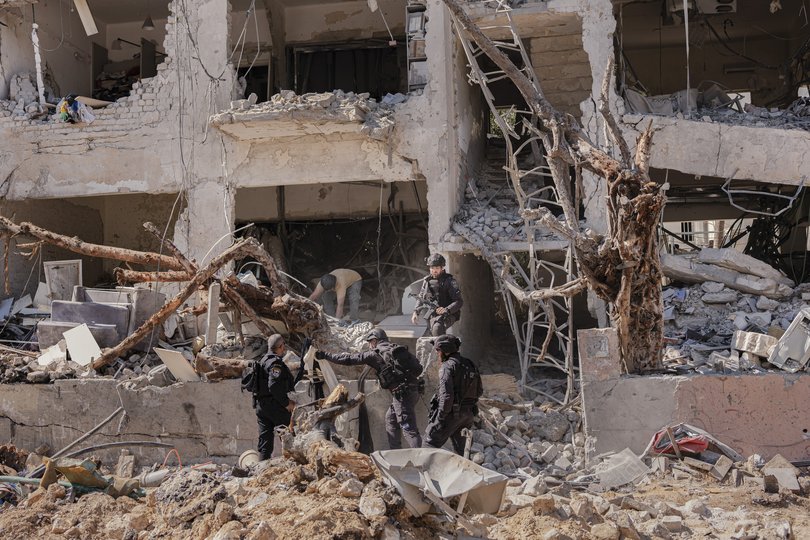 Israeli security officials inspect the site of an Iranian missile strike in Tel Aviv, Israel, part of Tehran’s retaliation for coordinated U.S. and Israeli airstrikes on Iran.