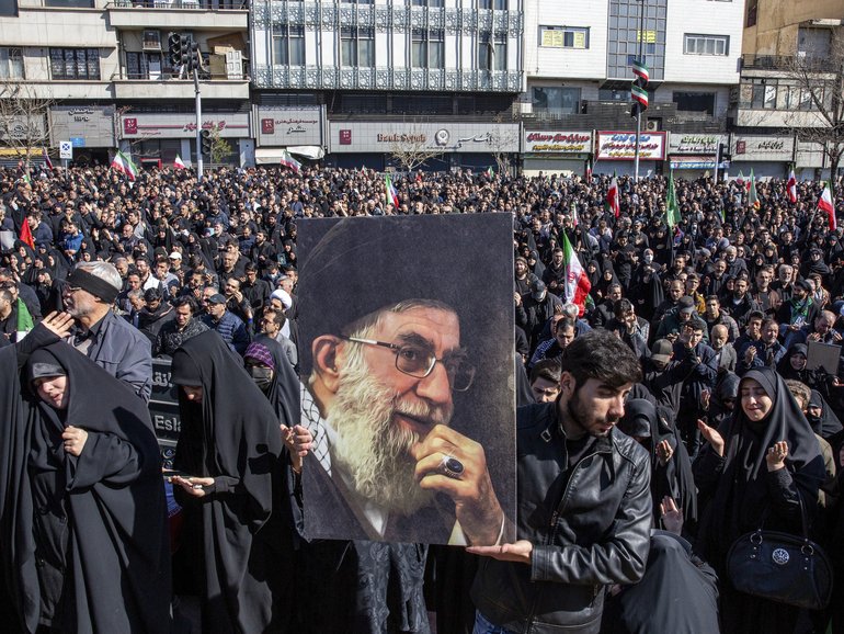 A man holds a portrait of Iran’s Supreme Leader Ayatollah Ali Khamenei as people mourn his killing at a rally in Tehran, Iran.