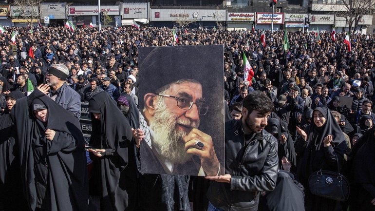 A man holds a portrait of Iran’s Supreme Leader Ayatollah Ali Khamenei as people mourn his death at a rally in Tehran.
