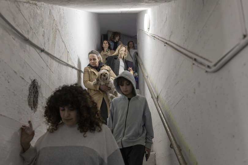People enter a public bomb shelter as a siren sounds to warn of incoming missiles from Iran in Rishpon, Israel.