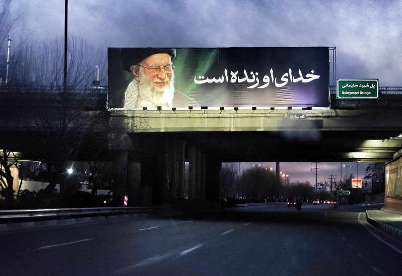 A billboard featuring a portrait of Ayatollah Ali Khamenei is displayed on an overpass in Tehran.