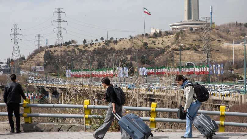People carrying their belongings in luggage in Tehran.