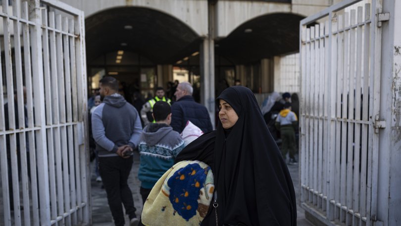 A woman arrives with belongings at a school in Beirut, Lebanon that was converted into a shelter for the displaced amid Israeli airstrikes.