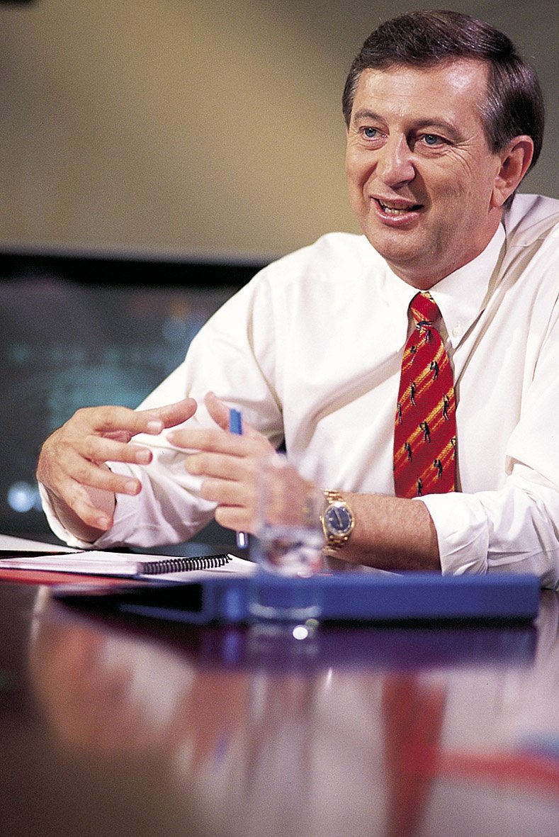 Dennis Cometti at the desk.