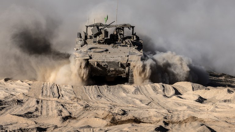 An armored personnel carrier travels along a security fence after crossing back to the Israeli side of the border with the Gaza Strip in October.
