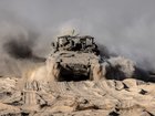 An armored personnel carrier travels along a security fence after crossing back to the Israeli side of the border with the Gaza Strip in October.