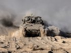 An armored personnel carrier travels along a security fence after crossing back to the Israeli side of the border with the Gaza Strip in October.