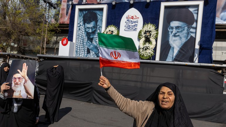  A woman waves an Iranian flag in front of portraits of Ayatollah Ali Khamenei in Tehran this week.