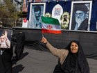  A woman waves an Iranian flag in front of portraits of Ayatollah Ali Khamenei in Tehran this week.