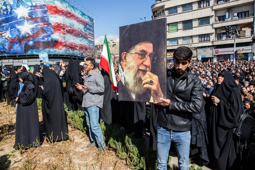 A man holds a photo of Iran’s supreme leader, Ayatollah Ali Khamenei, as people mourn his killing at a rally in Tehran.