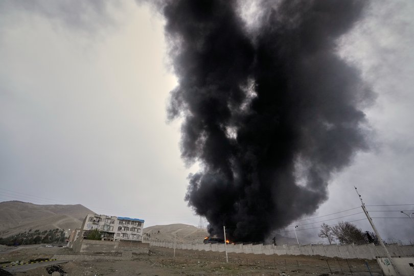 A thick plume of smoke from a U.S.-Israeli strike on an oil storage facility late Saturday lingers in the cloudy sky over Tehran.