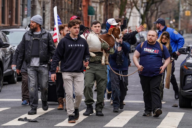 Right-wing influencer Jake Lang carries a goat the protest.