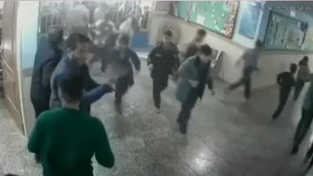 Children run, some with hands over their ears.