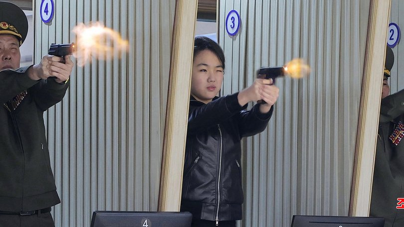 North Korean leader Kim Jong Un's daughter Kim Ju Ae test-firing a new pistol at a shooting gallery.