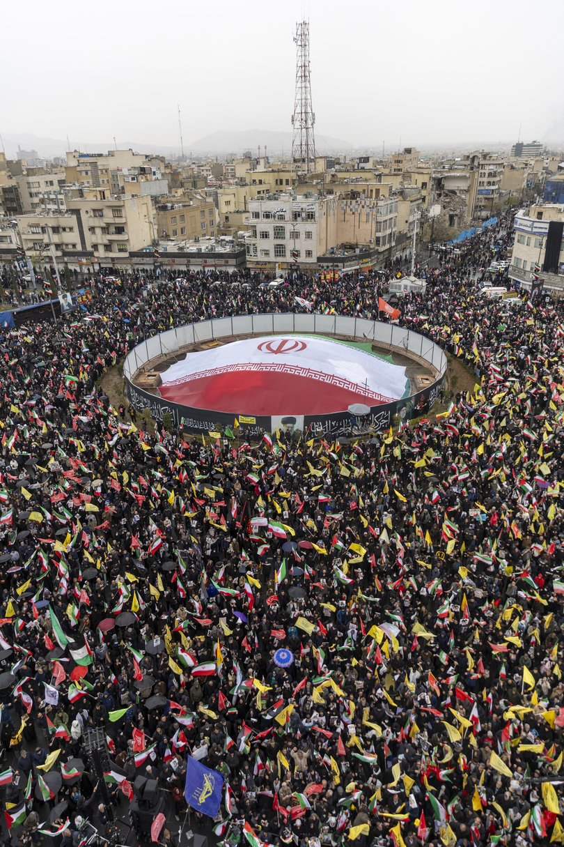 Crowds wave flags during a Quds Day demonstration on March 13, 2026 in Tehran, Iran.