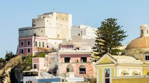 A pink Citroën Mehari climbs Ponza’s only road at dusk.