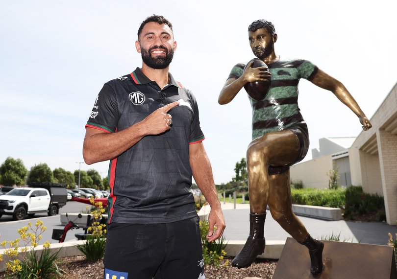 Alex Johnston poses next to a statue in his honour to celebrate becoming the highest NRL try scorer.