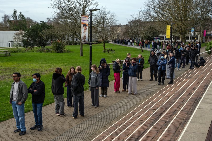 Staff and students queue to receive a vaccine after an outbreak of meningitis caused the deaths of two people in Canterbury, United Kingdom. 