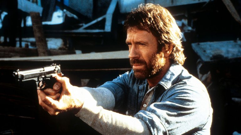 Chuck Norris points a gun in a scene from the film 'Hero And The Terror', 1988.
