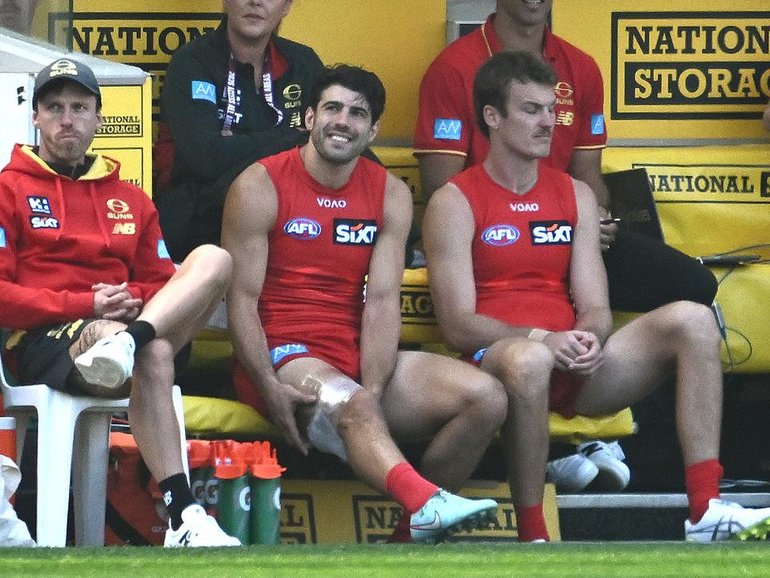 A strapped-up Christian Petracca watches from the bench as the Suns thrash the Tigers at the MCG.