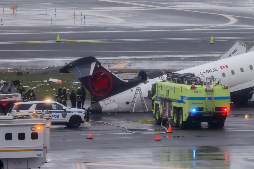 Emergency crews respond to an Air Canada Express plane on the tarmac after the plane collided with a fire truck at LaGuardia Airport.