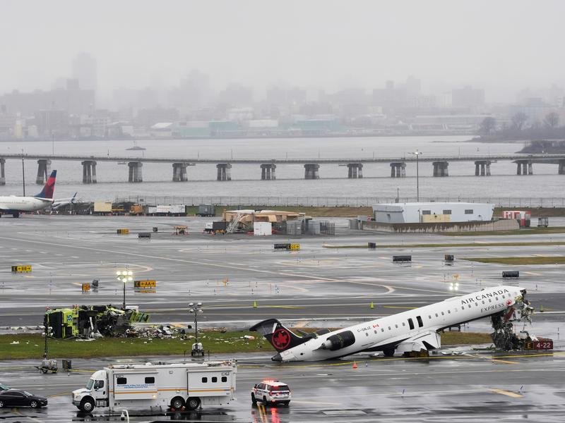 An Air Canada jet and a fire truck at New York's LaGuardia Airport after the deadly collision. (AP PHOTO)