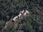 Satellite imagery shows a cluster of buildings within dense bushland near Canungra, Queensland, where interrogation training exercises have been conducted. 