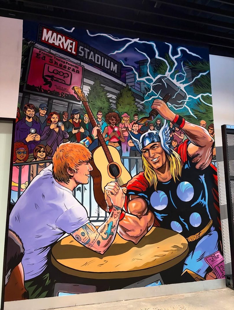 Ed Sheeran and Thor arm wrestle.