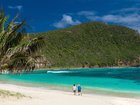 Couple enjoying a scenic walk along Neds Beach on Lord Howe Island.