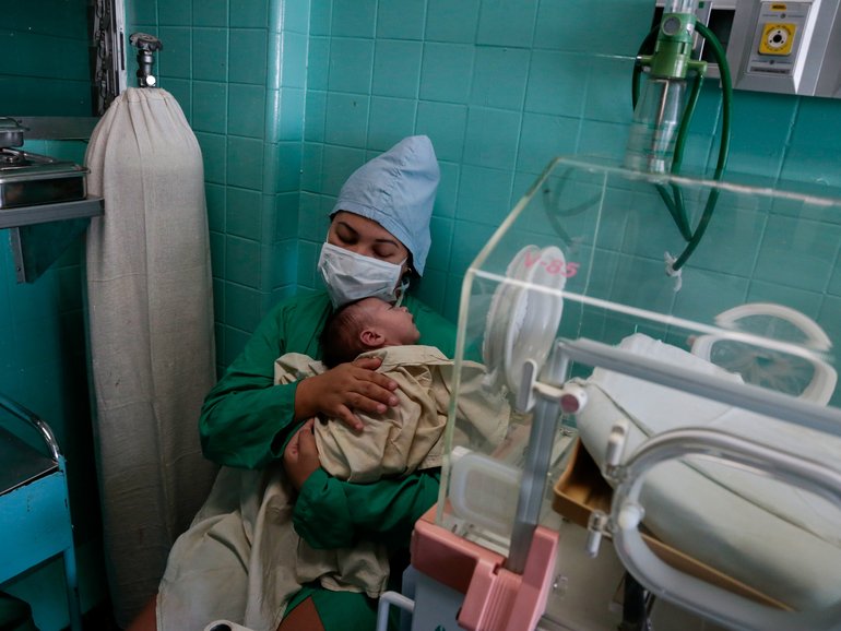 Liagny Acosta holds her 2-week-old baby, Aran, who is hospitalized for a respiratory illness at the Hospital William Soler in Havana on March 22, 2026. Amid a U.S. oil blockade causing daily blackouts across Cuba, doctors say that rapidly deteriorating conditions at hospitals and clinics are causing deaths that would otherwise be preventable. (Jorge Luis Baos/The New York Times)