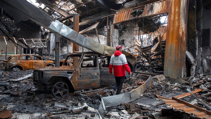 A worker with the Iranian Red Crescent Society walks through the rubble of a foreign car repair workshop that was destroyed during a joint U.S. and Israeli attack on March 28, 2026 in Tehran, Iran.