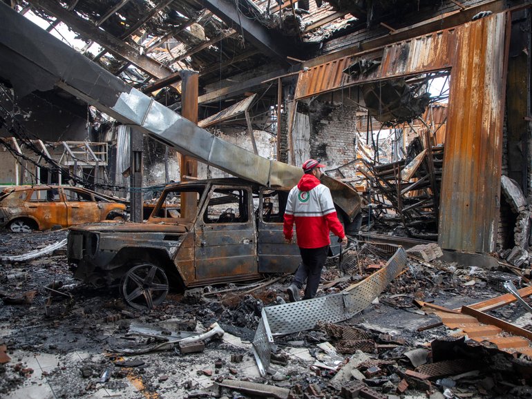 A worker with the Iranian Red Crescent Society walks through the rubble of a foreign car repair workshop that was destroyed during a joint U.S. and Israeli attack on March 28, 2026 in Tehran, Iran. 
