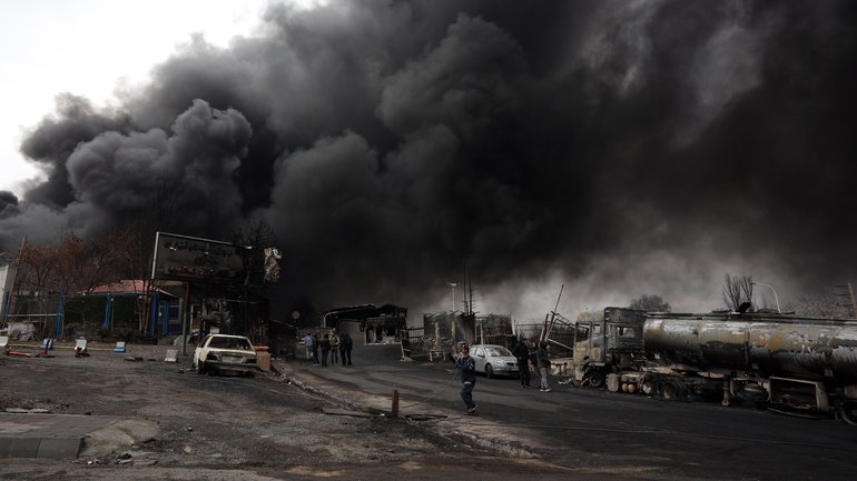 A view of the Main gate to the Shahran Oil Refinery as smoke rises.