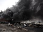 A view of the Main gate to the Shahran Oil Refinery as smoke rises.