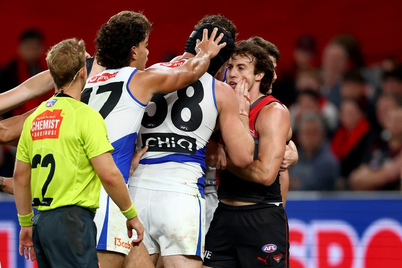 Tristan Xerri of the Kangaroos wipes blood on the face of Andrew McGrath.