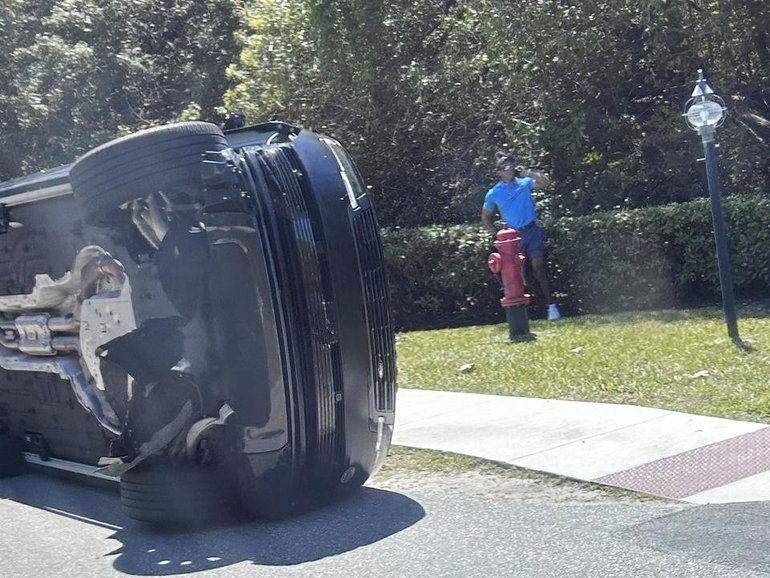 Tiger Woods stands by his overturned vehicle in Jupiter Island after last Friday's crash. 