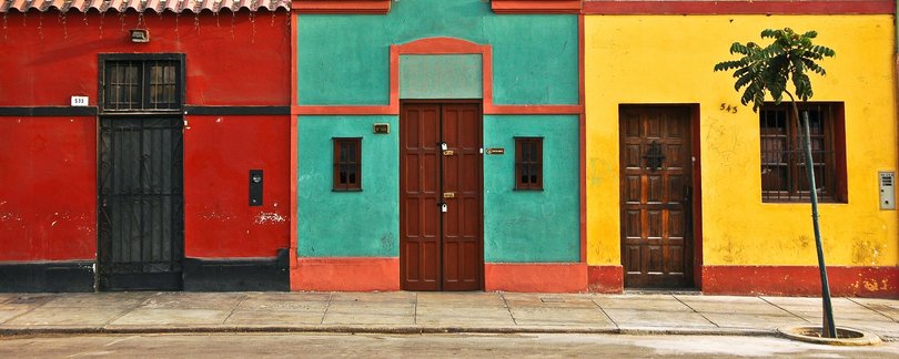 Vividly colored houses along the sidewalk in an old neighbourhood of Lima, Peru.